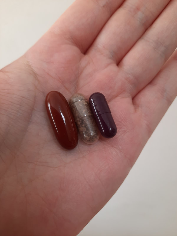Size comparison of capsules.  From L - R:  pregnancy multivitamin, size 00 plant-based placenta capsules, size 0 gelatin based placenta capsule